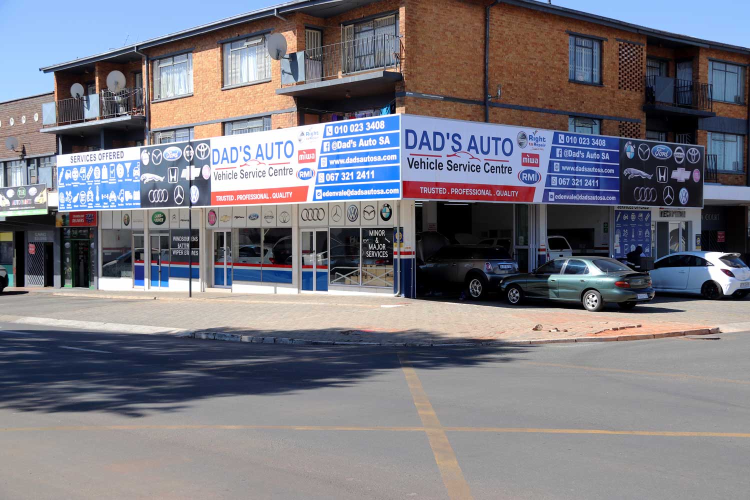 DAD'S Auto corner branding and workshop bays from the street