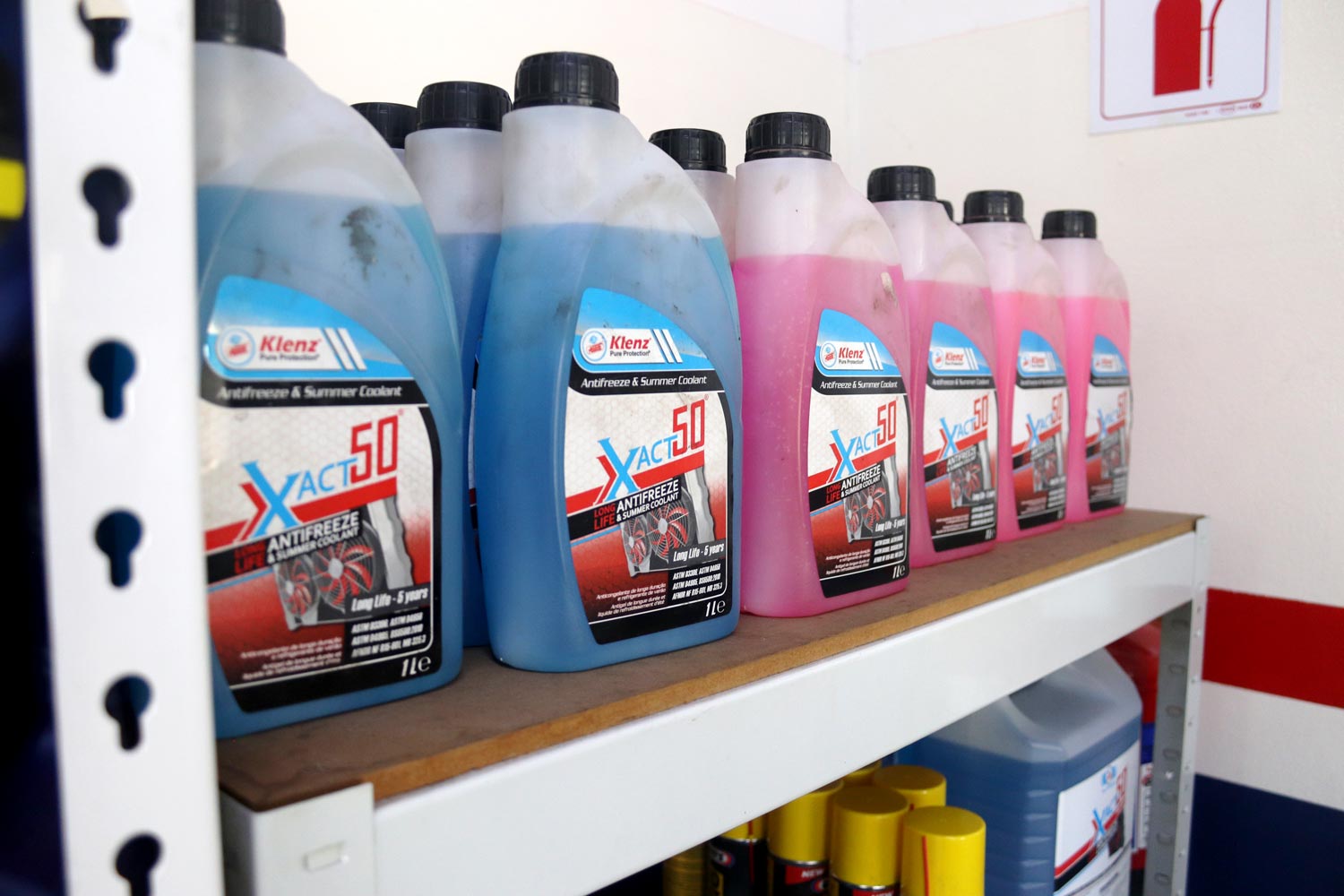 Antifreeze and summer coolant stock on the workshop shelf